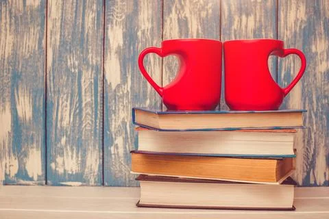 Two heart shaped mugs is on a stack of books 写真素材