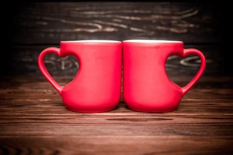 Two heart shaped mugs with tea on brown background 写真素材