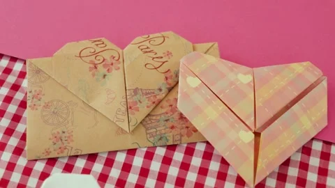 Two heart-shaped origami designs on pink and checkered backgrounds, Stock Footage 282999588