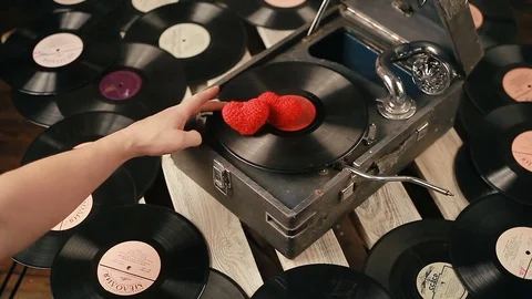 Two hearts and a gramophone. Close-up of man's hands rotating vinyl record. Stock Footage 83779696