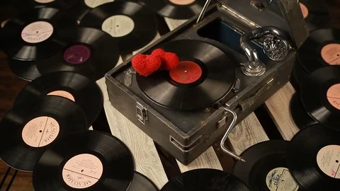 Two hearts and a gramophone. Close-up of man's hands rotating vinyl record. Stockbeeldmateriaal 83780208
