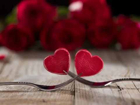 Two hearts between two forks on a table, close up Stock Photos