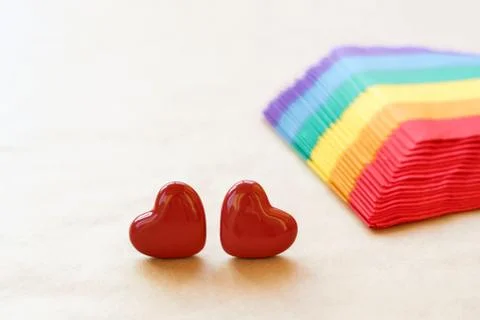 Two hearts lying on a stack of napkins painted under a rainbow on craft paper Stock-Fotos