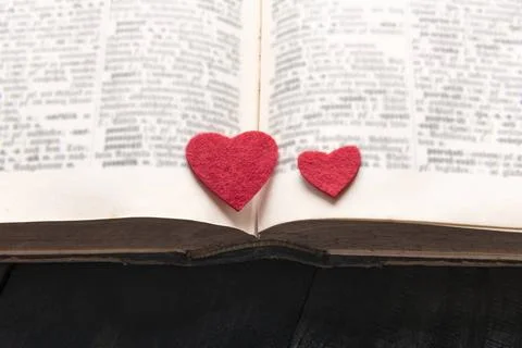 Two hearts on the pages of a book Close-up image with two red hearts place... Stock Photos
