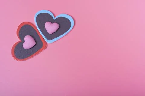 Two hearts on a pink background in the upper left corner and two small hearts Stock Photos