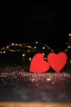 Two hearts side by side on a dark background and garlands 스톡 사진