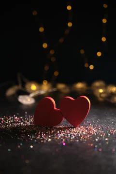 Two hearts side by side on a dark background and garlands Stock-Fotos