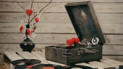Two hearts spinning on vinyl record on a vintage gramophone Stock Footage 83679853