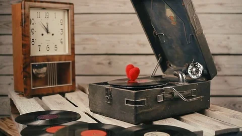 Two hearts spinning on vinyl record on a vintage gramophone Stock Footage 83681360