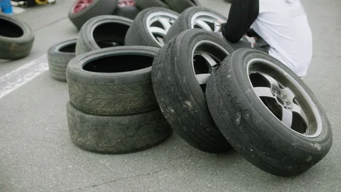 Two heavily worn sets of wheels lying on new tires in line for replacement Stock Footage 129345825