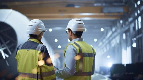 Two Heavy Industry Engineers Stand in Pipe Manufacturing Factory, Use Tablet Stock Footage 114869103