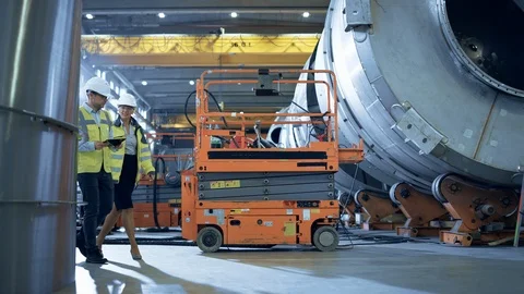 Two Heavy Industry Engineers Walk Through Pipe Manufacturing Factory, Use Tablet Stock Footage 114879398