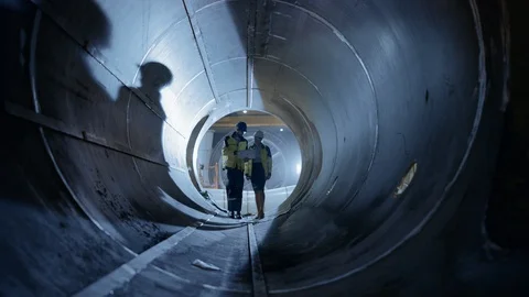 Two Heavy Industry Engineers Walking Inside Pipe, Use Laptop, Have Discussion 스톡 동영상 114813868