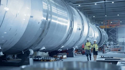 Two Heavy Industry Engineers Walking Through Pipe Manufacturing Facility Stock Footage