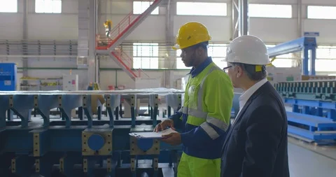 Two heavy industry workers walk through modern factory. Engineer in formal suit Stock Footage 121102016
