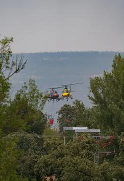 Two Helicopters Fighting Forest Fire in Wilderness Stock Photos