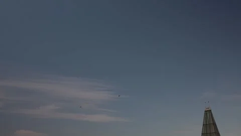 Two helicopters fly across the open sky surrounded by soft pastel clouds creatin Stock Footage 312697108