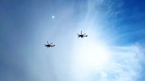 Two helicopters flying in blue sky. Silhouettes of helicopters. Shining sun Stock Footage 297626272