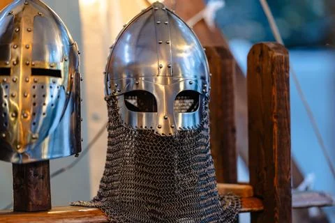 Two helmets, one of which is a knight's helmet, are displayed on a wooden sta Foto stock