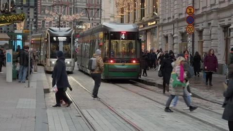 Two Helsinki trams line 4 at busy city street with walking pedestrians Stock Footage 326637816