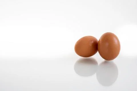 Two hen or chicken eggs isolated on white background with reflex on glass Stock Photos