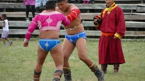 Two heroes try to grab and knock each other. Mongolian holiday Naadam. Video stock 87442524