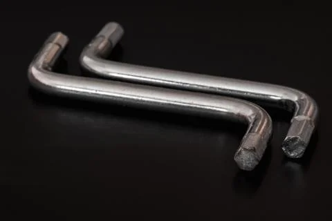 Two hexagon socket screw s shaped allen keys in a black background Stock Photos