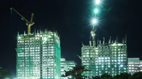 Two high buildings under construction with cranes at night. Timelapse. Stock Footage 61237958