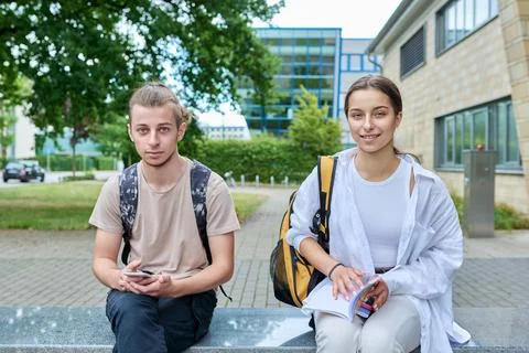 Two high school students guy and girl outdoor, school building background Fotos de archivo