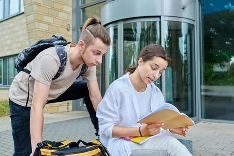 Two high school students guy and girl outdoor, school building background Fotos de archivo
