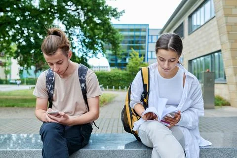 Two high school students guy and girl outdoor, school building background Fotos de archivo