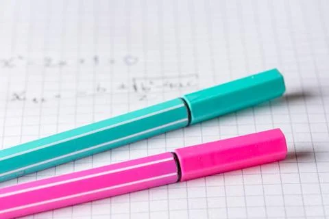 Two highlighters on school graph paper with math equation Stock Photos