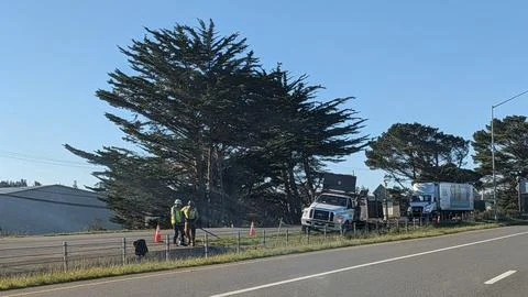 Two highway workers in reflective vests stand near service 库存照片