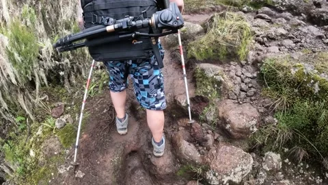 Two hiker guys are walking along a rocky mountain path Video stock 169337994