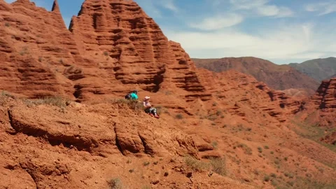 Two hikers are resting on one of the peaks of the Konorchek canyons Stock Footage 276645522