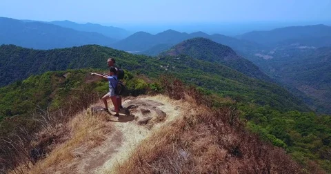 Two hikers with backpacks on the top of a mountain Stock Footage 77436251