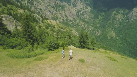 Two hikers couple resting on the top of the mountain and looking at the valley Stock-Footage 158208868