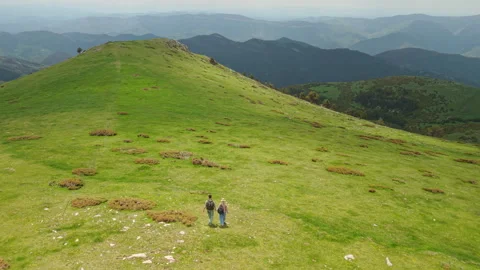 Two Hikers on a Green Pyrenees Mountain Ridge Stock Footage 345265228