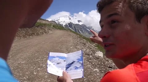 Two hikers looking at map and pointing at mountains Stock Footage 43249198