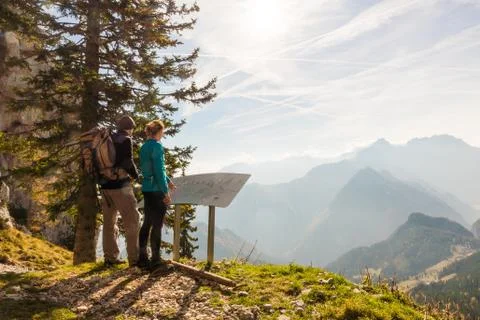 Two hikers looking at the map and admiring the view over the valley in Slovenia Stock Photos