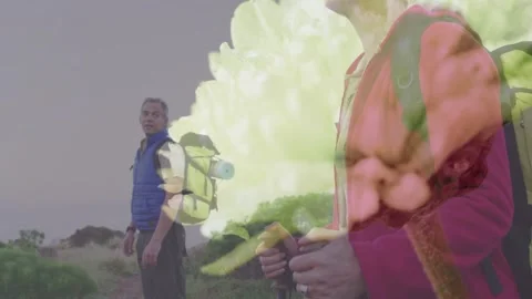 Two hikers pausing on coast, camera panning showing floral overlay blending with Stock Footage 333631685
