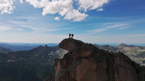 Two Hikers Reach Summit of Mountain Peak on Sunny Day Stock Footage 278321949