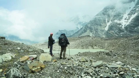 Two hikers standing on the mountain and looking at the river Video stock 77450827
