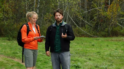 Two hikers stop to look at something in the woods. Stock Footage 31854653