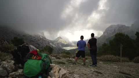 Two hikers talking &amp; contemplating Cuber reservoir while taking break 스톡 동영상 147392627