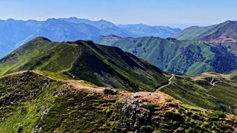 Two Hikers Walk Ridge Trail Above Green Peaks at Col d Aubisque Stock-Footage 341537107