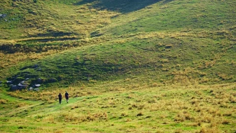 Two hikers walking in the mountains. Stock Footage 204851378