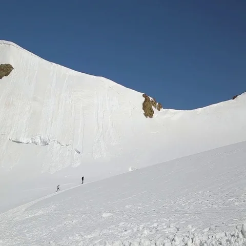Two hikers walking on top of snow mountain Stock Footage 69464115