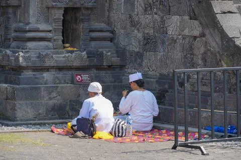 Two Hindus are praying in front of a stone at the Prambanan temple in Indonesia. 스톡 사진