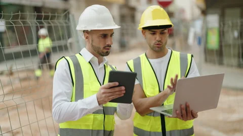 Two hispanic men architects using touchpad and laptop working at street Stock Footage 232873281